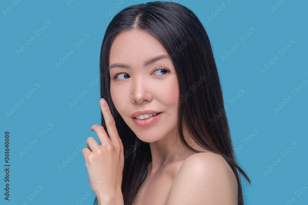 Smiling dark-haired model on a blue background Smiling dark-haired model on a blue background