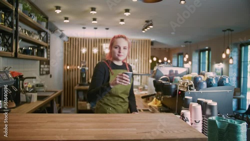 A young Barista Girl Makes delicious coffee. Coffee shop worker with a modern hairstyle, Fashionable Barista, Modern gir