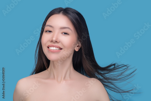 Smiling young dark-haired woman with fluttering hair