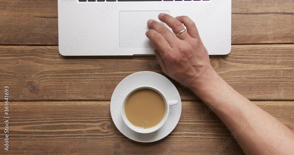 Top view of man work on laptop and drink coffee with milk Top view of man work on laptop and drink coffee with milk