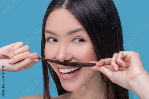 Woman making moustaches from her long hair