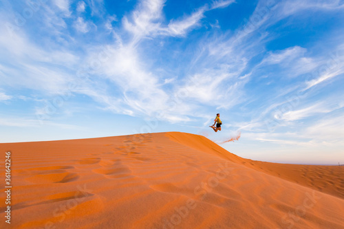Young man on Red sand dunes in Vietnam