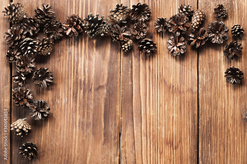 Composition of brown pinecones on a brown wooden background. Christmas and New Year background. Place for text.