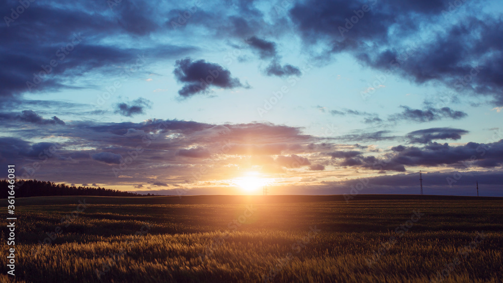 The bright light of the setting sun over the field - an impressive colorful sunset The bright light of the setting sun over the field - an impressive colorful sunset