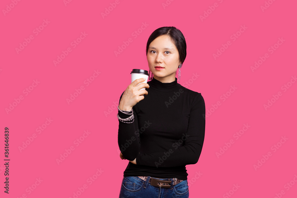 Portrait of a woman holding a paper take away cup over pink background. Portrait of a woman holding a paper take away cup over pink background.