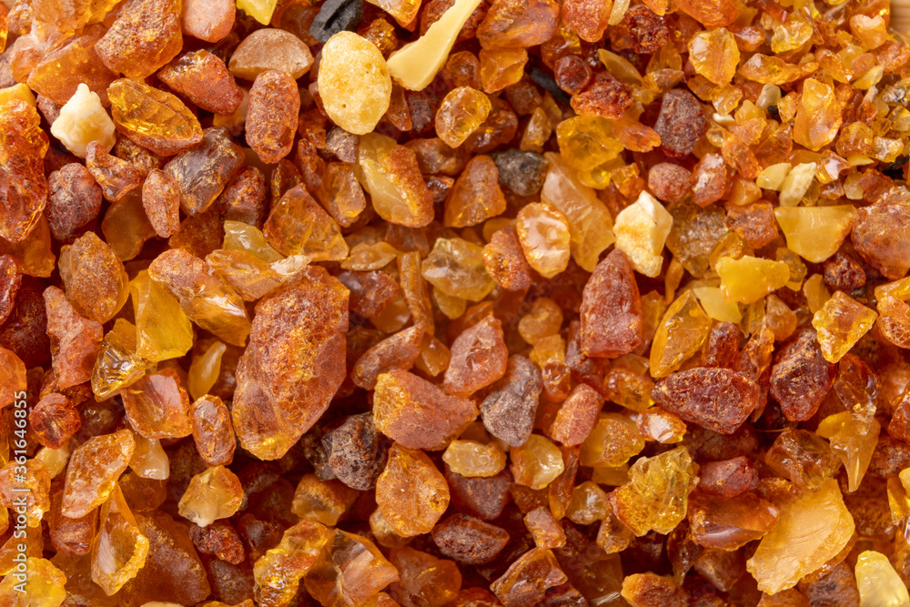 Raw small pieces of amber arranged on a wooden board. Precious pieces of old Baltic resin. Dark background. Raw small pieces of amber arranged on a wooden board. Precious pieces of old Baltic resin. Dark background.