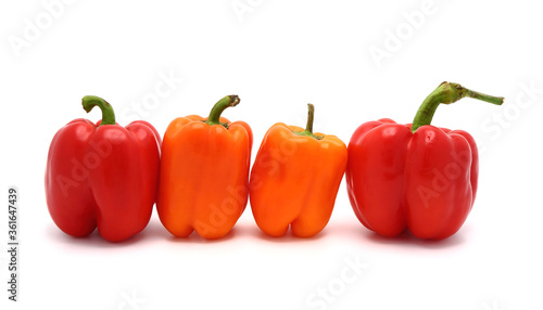 Two red and two orange ripe sweet peppers on a light background. Natural product. Natural color. Close-up.