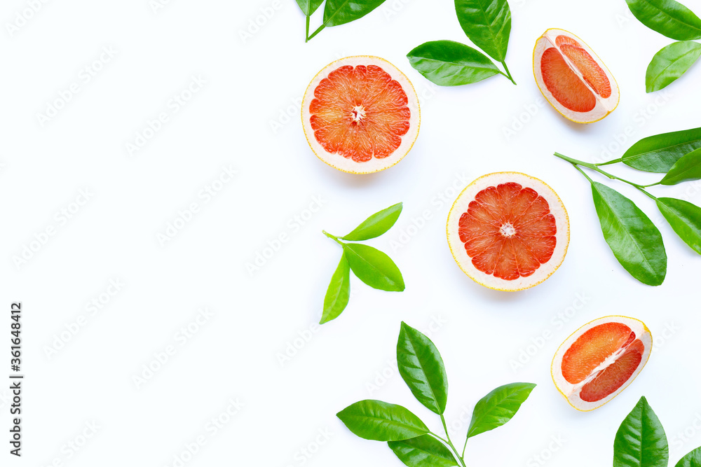 Naklejka premium High vitamin C. Juicy grapefruit slices with green leaves on white background.