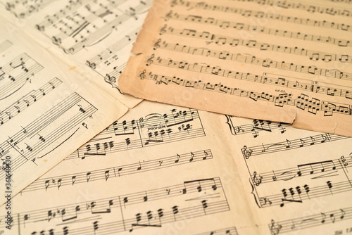 Old sheets with music notes scattered on the table. Close-up. Retro style. Selective focus.