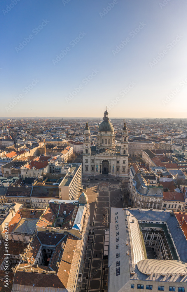 Aerial drone shot of St. Stephen's Basilica with empty square in Budapest sunrise glow