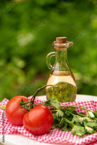 Olive oil with tomatoes and herbs in the fresh air. Summer salad ingredients.