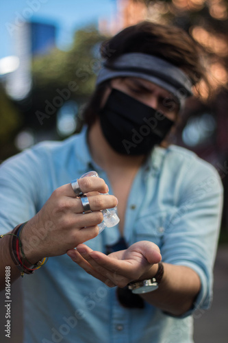 Man applying antibacterial gel in the street