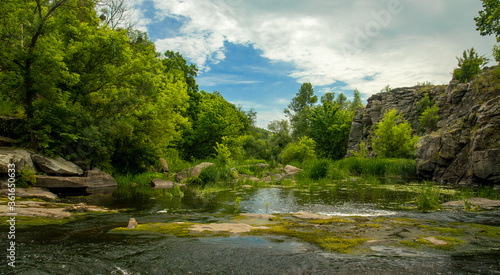 soft focus on foreground summer landscape clear weather day time rocky river stream scenic view in green trees foliage nature environment
