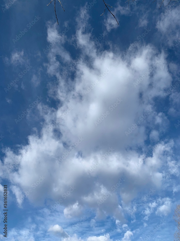 Altocumulus white and silver clouds against a bright blue sky. Altocumulus white and silver clouds against a bright blue sky.