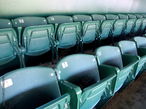 Two Rows of numbered green seats in stadium