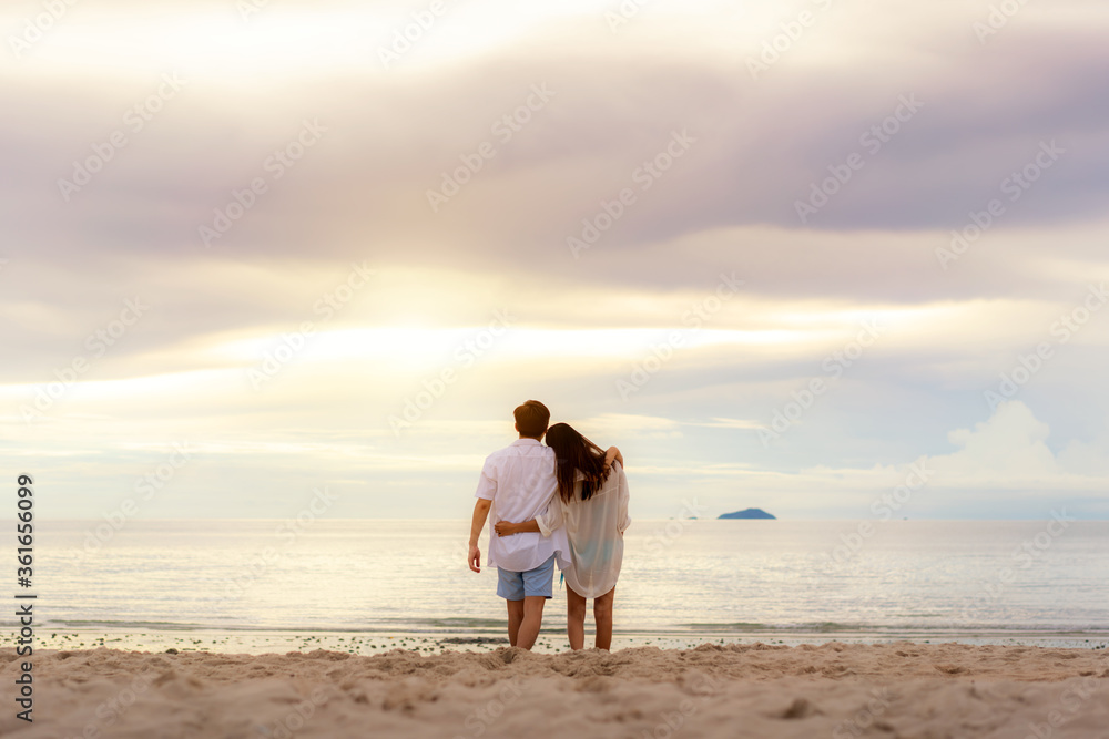 Romantic Asian young couple in love hugging and looking togerther and laughing at sunset on beach to happy while they honeymoon. Summer Vacation and Holidays concepts. Romantic Asian young couple in love hugging and looking togerther and laughing at sunset on beach to happy while they honeymoon. Summer Vacation and Holidays concepts.