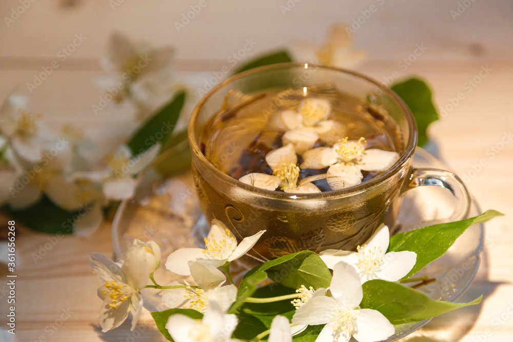 jasmine tea in soft warm evening light with fresh jasmine leaves and flowers jasmine tea in soft warm evening light with fresh jasmine leaves and flowers