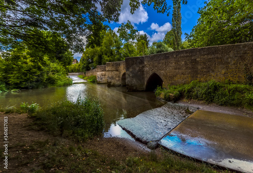 A panorama view of the bridge and ford over the River Ise in the town of Geddington, UK in summer photo