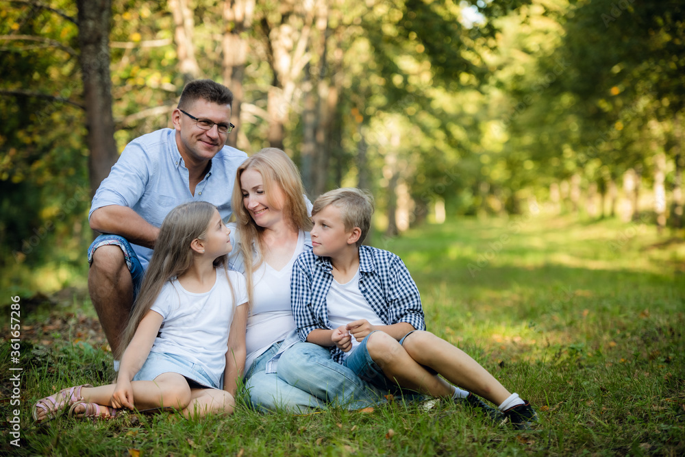 Fototapeta premium Happy family outdoors smiling in a summer forest