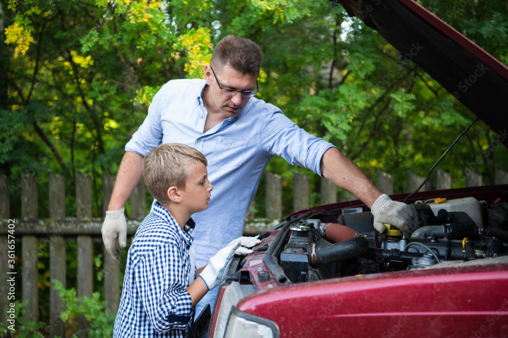 A father and son working together restoring an engine of their truck