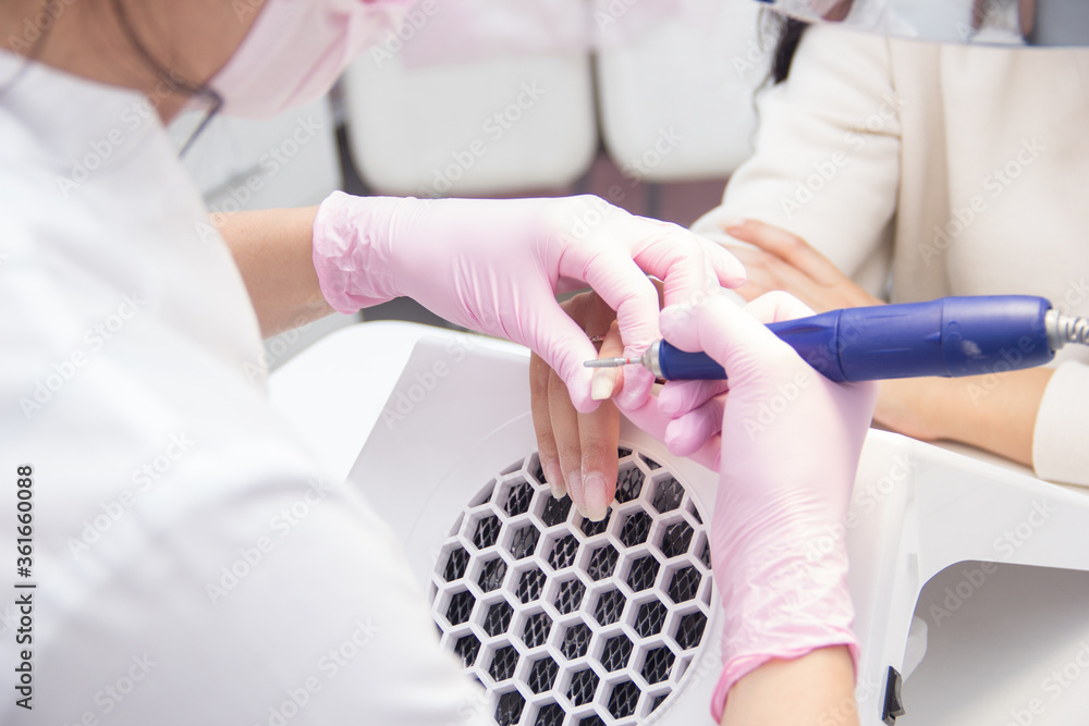 Nail service. Hardware manicure. A manicurist does a hardware manicure in a nail salon. Hand care. A specialist makes a hardware manicure. There are professional devices nearby. Nail service. Hardware manicure. A manicurist does a hardware manicure in a nail salon. Hand care. A specialist makes a hardware manicure. There are professional devices nearby.