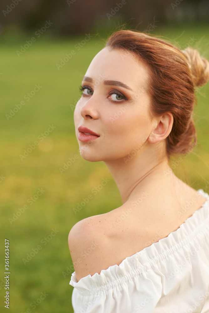 Young pretty woman natural outdoor closeup face portrait. Beautiful girl with red hair in bun Young pretty woman natural outdoor closeup face portrait. Beautiful girl with red hair in bun