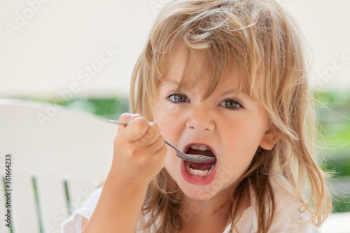 little girl eats honey