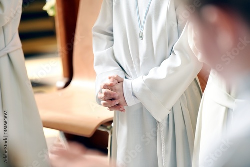 Her first holy communion. Close up of hands of a child together in prayer during a ceremony.