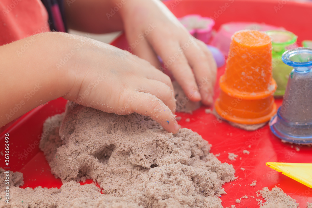 little hands playing with kinetic sand