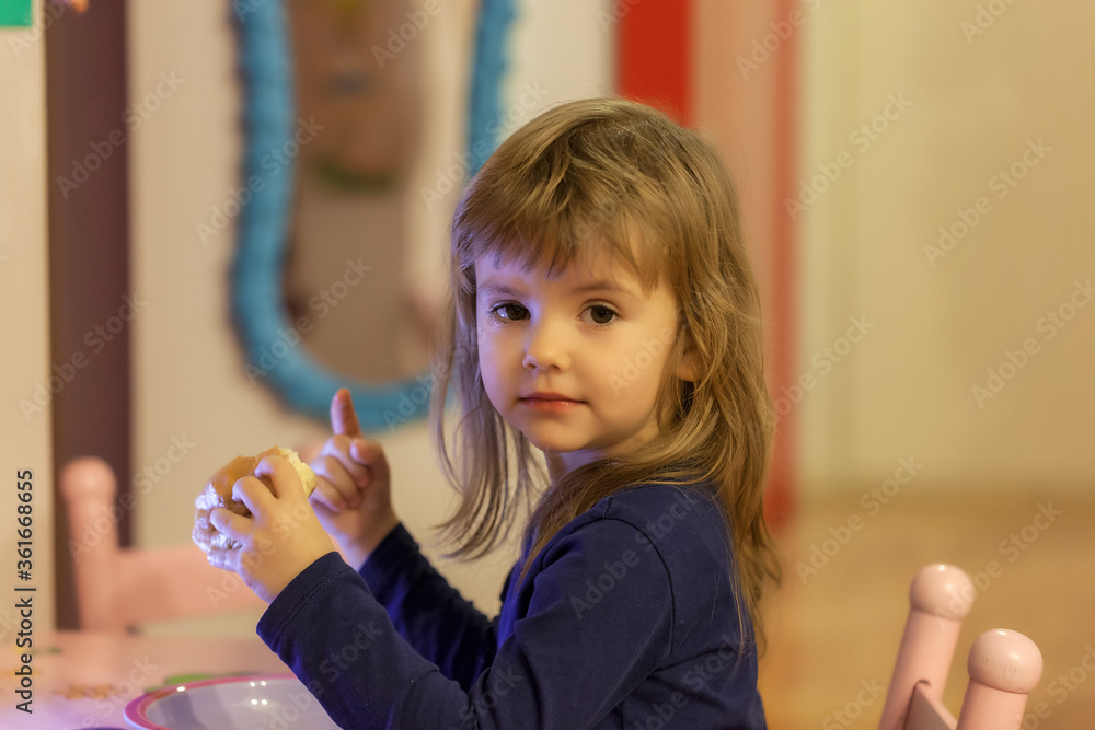 a little girl eating a donut