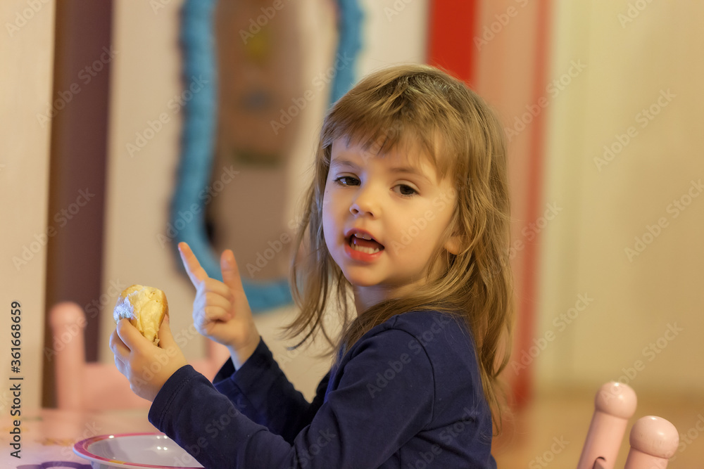 a little girl eating a donut