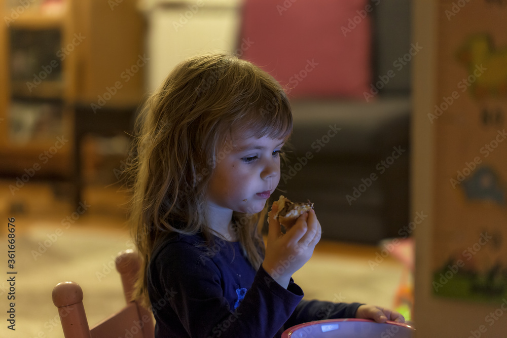 a little girl eating a donut
