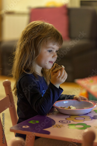 a little girl eating a donut