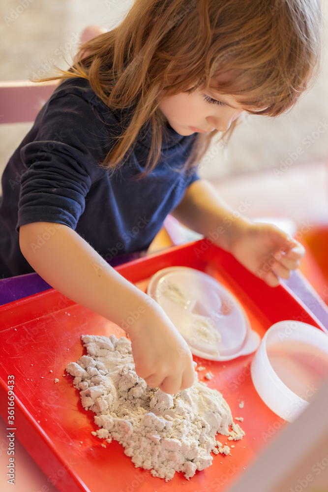 little girl playing with kinetic sand