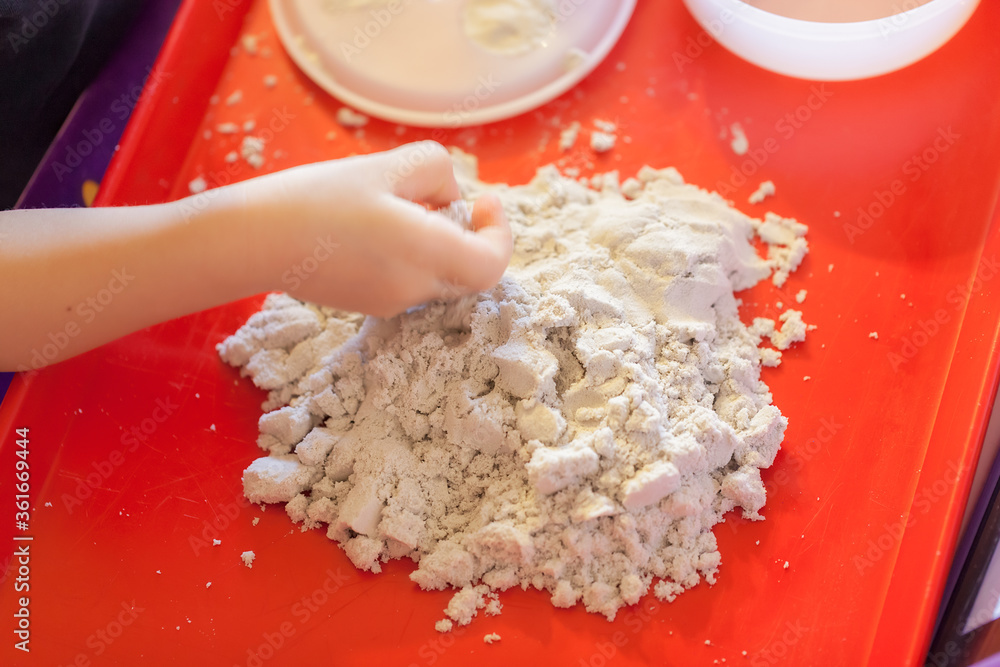 little girl playing with kinetic sand