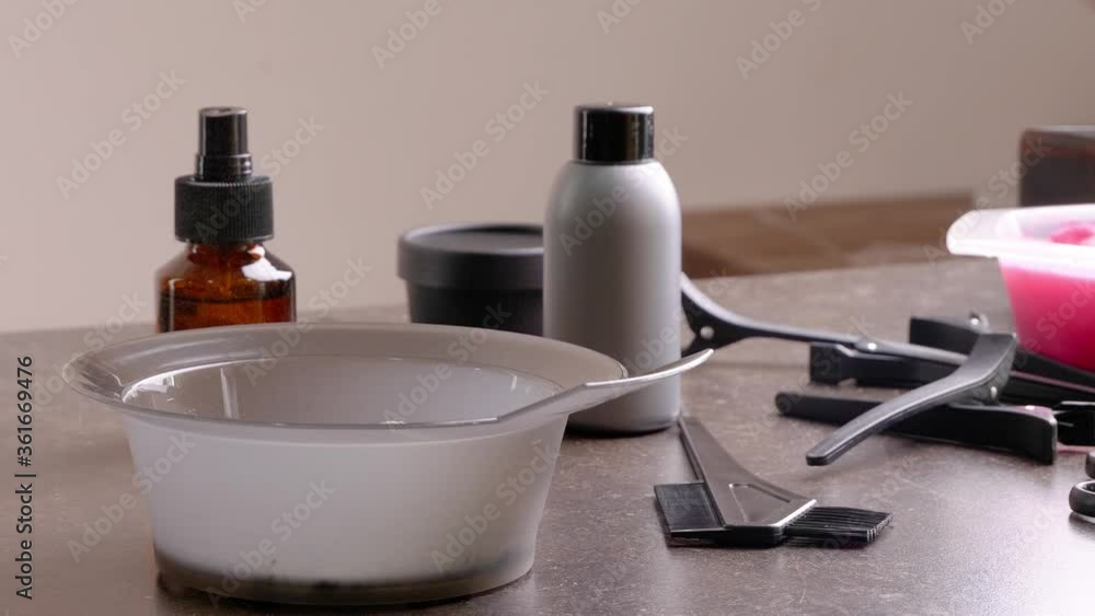 Hairdresser pouring dye powder into bowl on table in salon Hairdresser pouring dye powder into bowl on table in salon