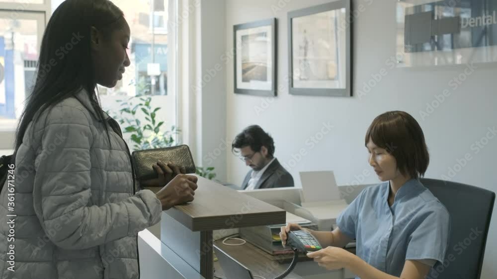 Patient using card reader to pay at front desk Patient using card reader to pay at front desk