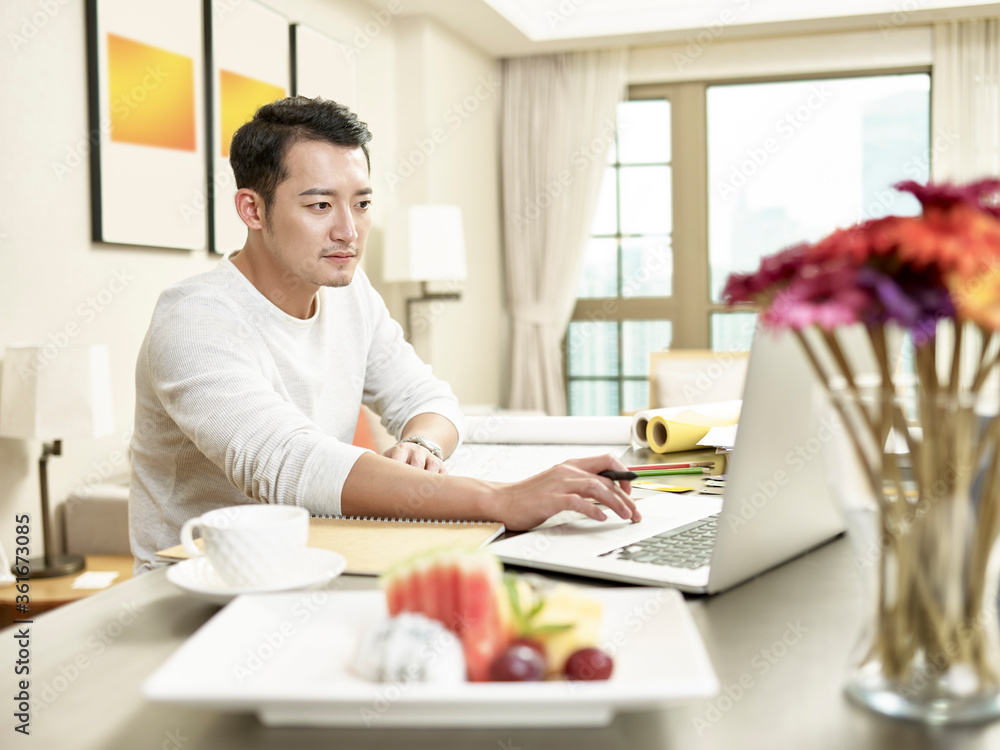 young asian businessman working from home using laptop computer young asian businessman working from home using laptop computer