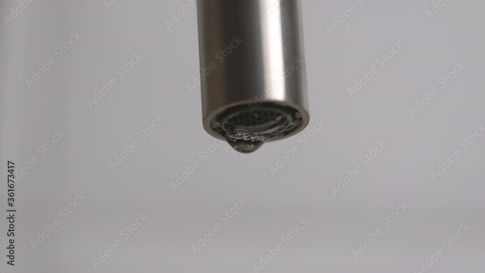 Dripping steel faucet. Close up. Slow motion Dripping steel faucet. Close up. Slow motion