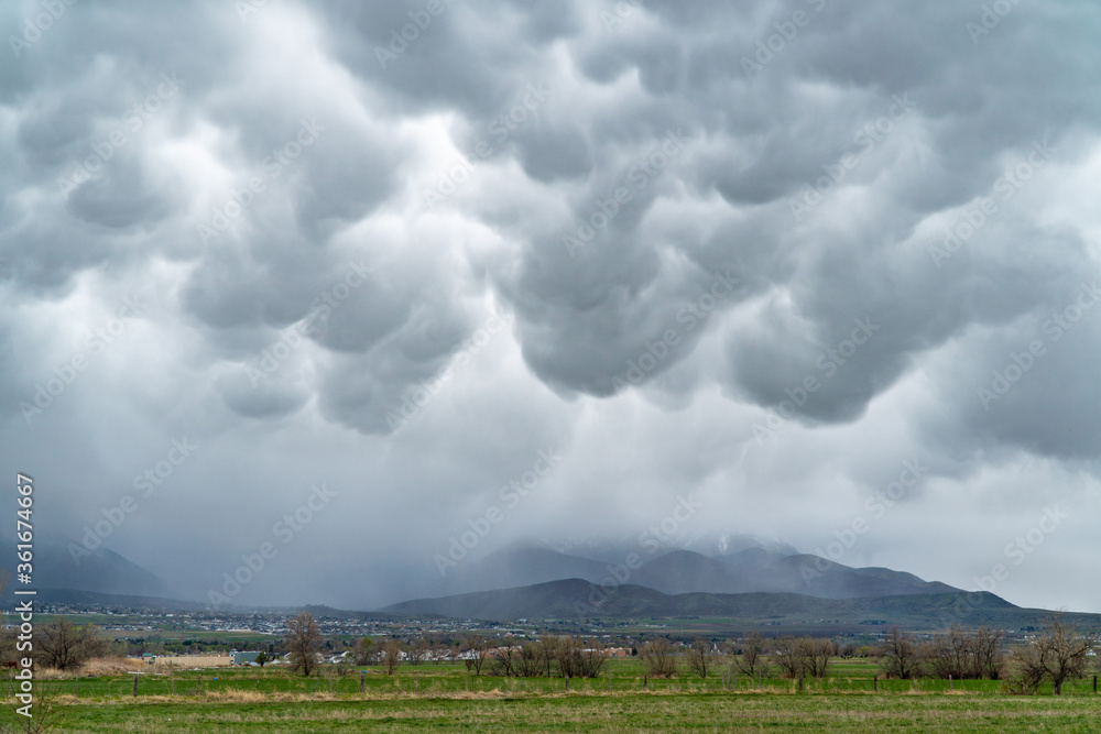 Mammatus clouds in the sky during rain storm over mountains in Utah