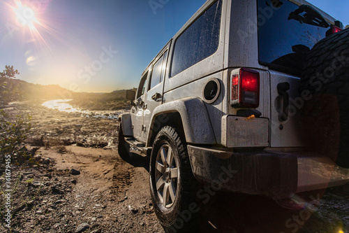 Jeep 4x4 from behind looking toward stream and sun Trabucco Canyon California