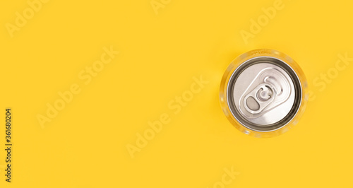 Metal can lid of water on yellow background. Monochrome image. Creative idea, new package of clear water in plastic bottle as can. Top view. photo