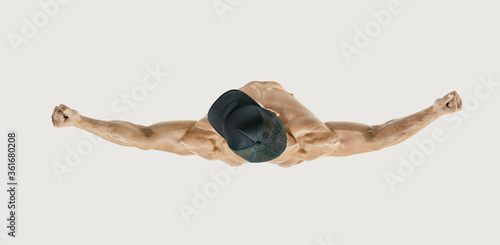 Top view shot of healthy muscular young man with black baseball cap. Shirtless male bodybuilder with muscular build rising muscular power hands. White backround. Image with clipping path