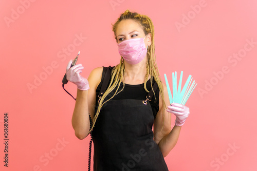 girl manicure master with a device on a red background