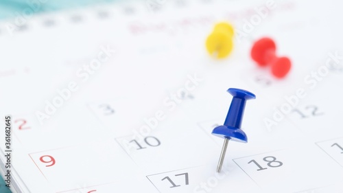 mark the event day with a pin. Thumbtack in calendar concept for busy timeline organize schedule,appointment reminder. planning business meeting or travel holiday planning concept. soft focus © methaphum