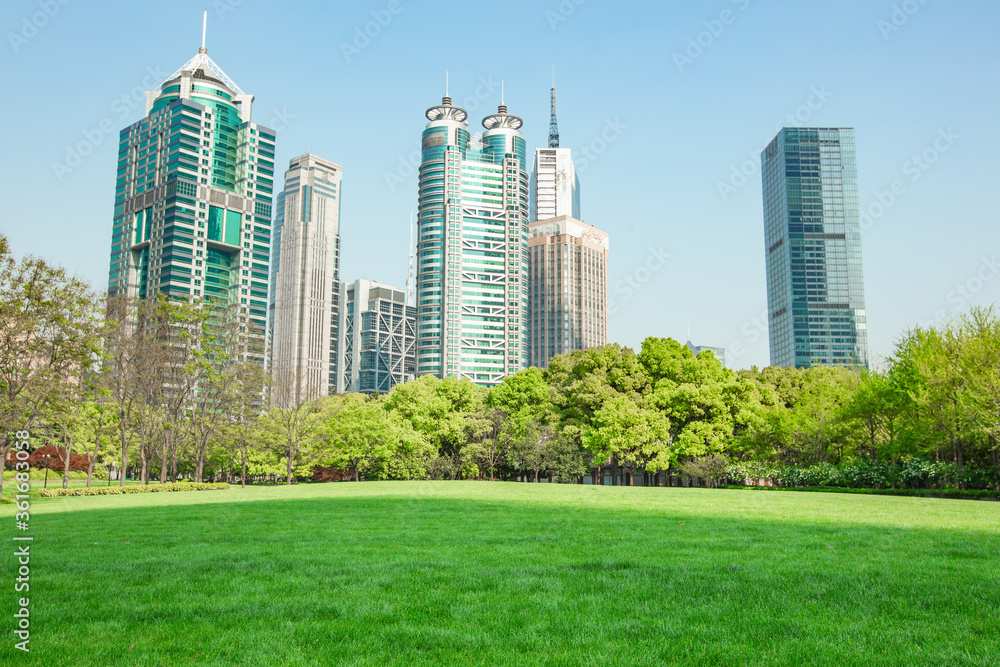 Obraz premium Central Park in Lujiazui, a big lawn in front of the modern skyscrapers.