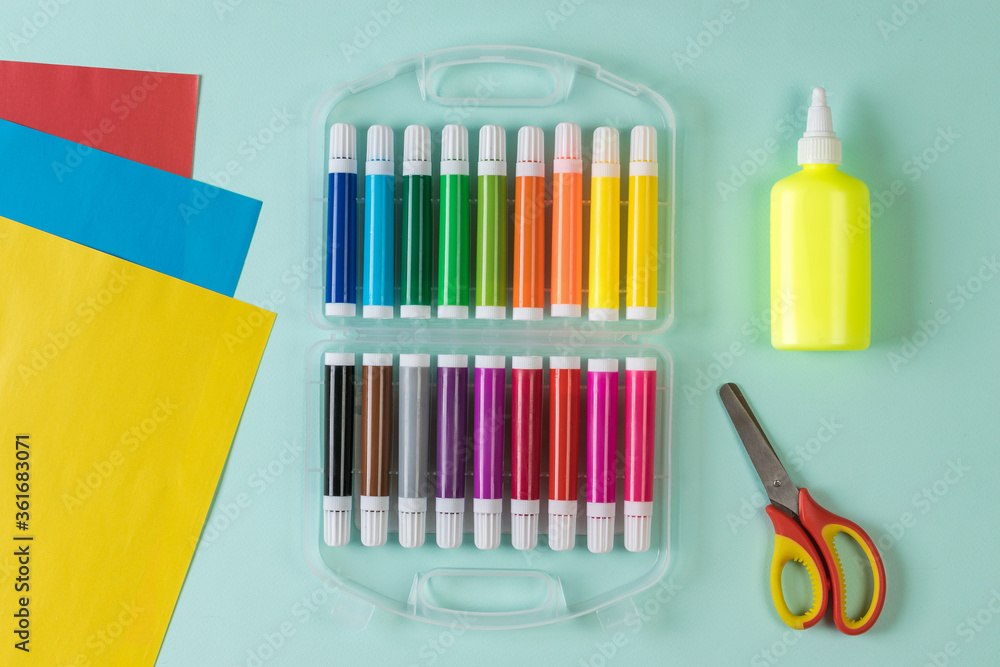 Obraz premium Scissors, glue, markers and colored paper on a light background.