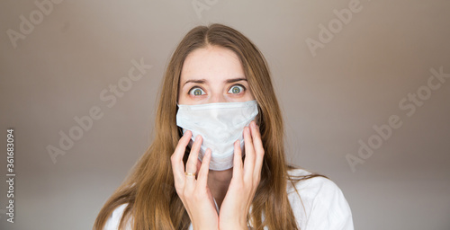 Portrait of a girl who covered her face with a mask. Frightened eyes of the patient.