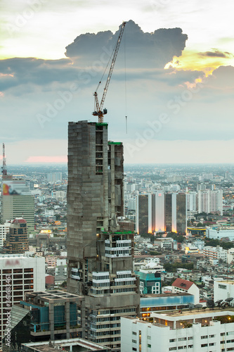 Construction site with cranes in the business district at dusk
