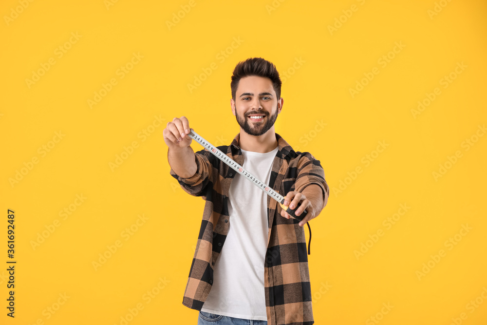 Young man with measuring tape on color background Young man with measuring tape on color background